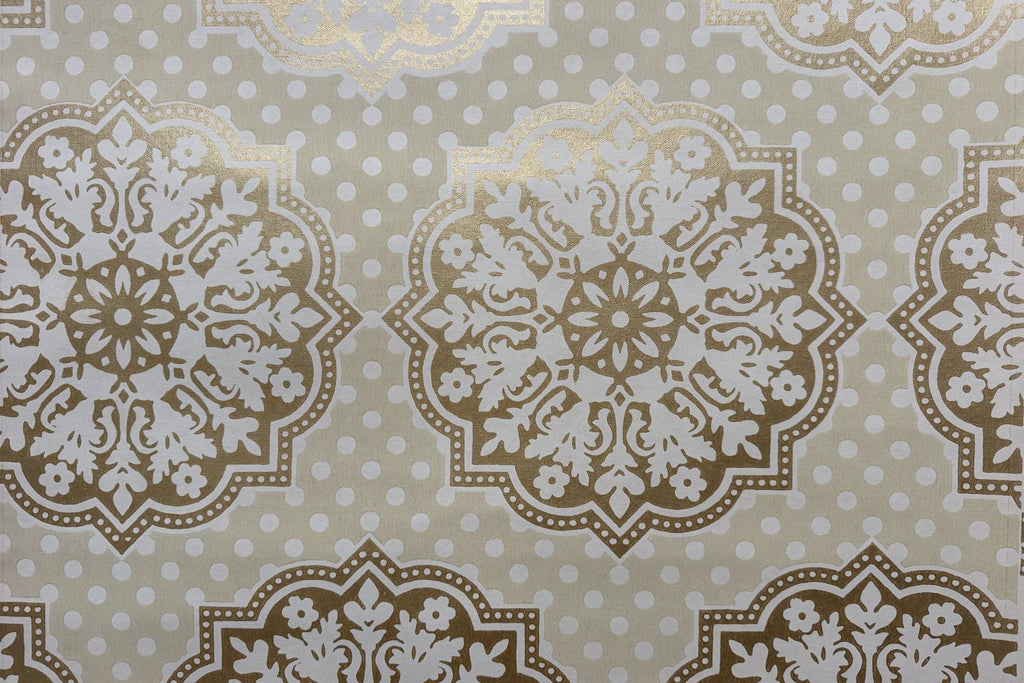 A close-up of a repeating damask-style wallpaper in warm beige, white, and metallic gold, with small white polka dots across a light beige background.