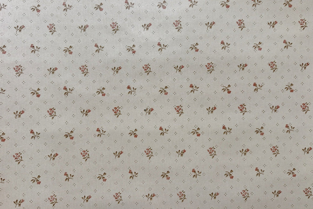 A close-up of a wallpaper pattern featuring a repeating small floral motif in muted red and brown on a warm off-white background.